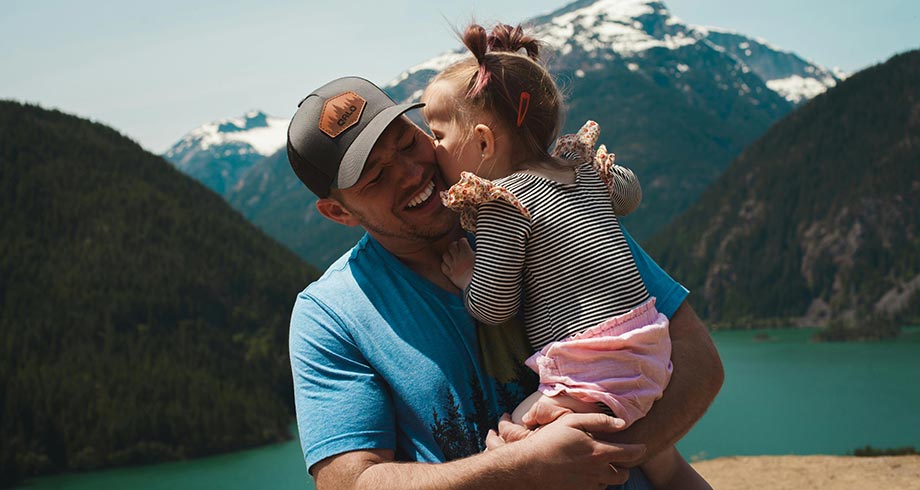 Dad and daughter enjoying the view of a beautiful lake
